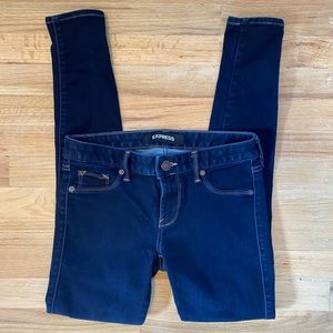 Express women’s dark wash low rise jean leggings.